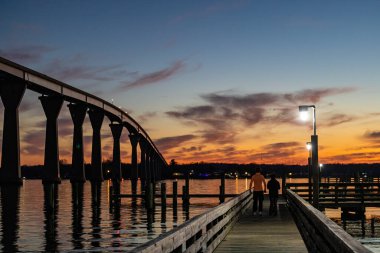 Solomons, Maryland USA Solomons Köprüsü 'nün altında bir iskelede genç bir çift, ya da Gov. Thomas Johnson Köprüsü