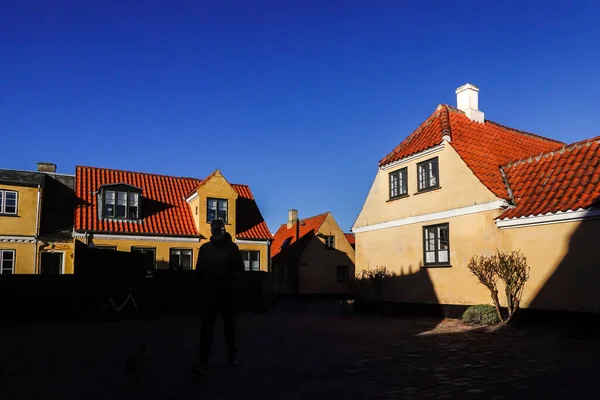Dragor, Denmark  Strong shadows on a picturesque square in Dragor with tradiotnal houses and a man\'s silhouette.