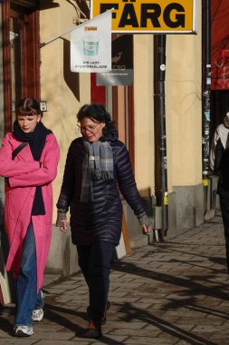 Stockholm, İsveç Kadınlar Hornsgatan caddesinde yürür güçlü bir kış günü öğleden sonra bir boyacının önünden geçer ve.