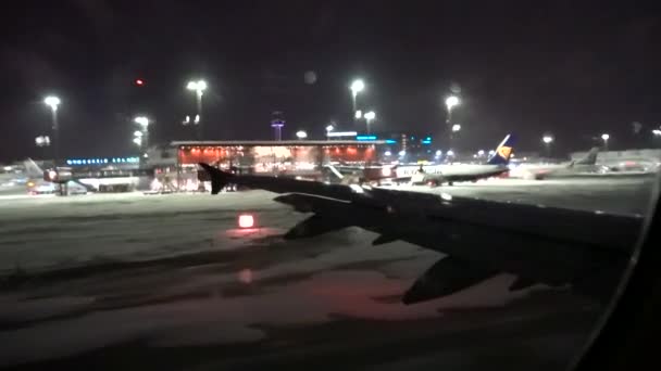 ストックホルム スウェーデン夜間の離陸前に雪上滑走路を走行する飛行機 — ストック動画
