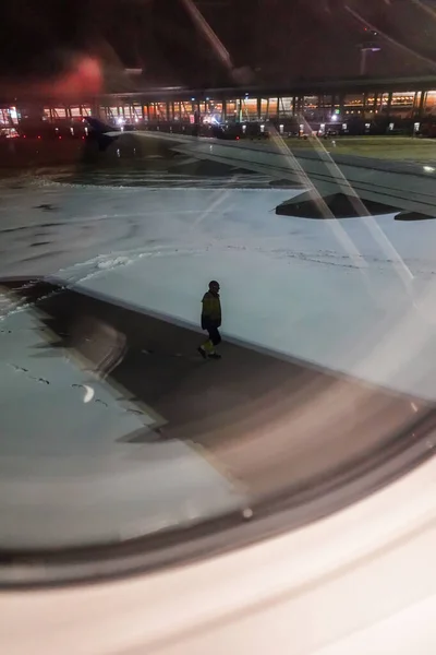 スウェーデンのストックホルム技術者は吹雪の中 Arlanda空港のTarmacの飛行機の翼の下を歩く — ストック写真