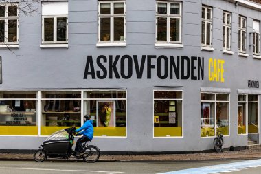 Kopenhag, Danimarka Norrebro bölgesindeki modaya uygun bir kafenin önünde motosiklet süren bir adam..