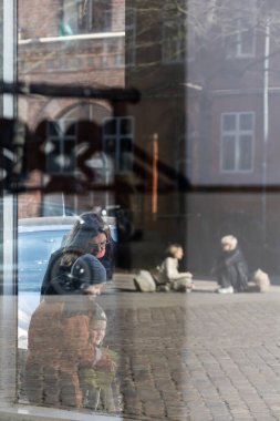 Kopenhag, Danimarkalı yayalar Norrebro semtindeki sokakta bir butik pencereden ve yansımalardan görüldü..