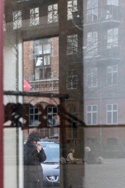 Kopenhag, Danimarkalı yayalar Norrebro semtindeki sokakta bir butik pencereden ve yansımalardan görüldü..