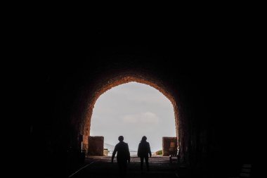 Kerak, Jordan, Kerak Kalesi 'ndeki arka aydınlatma tünelinde yürüyen insanlar.