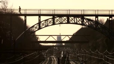 Kopenhag, Danimarka Carlsberg viyadük, 1899 'dan kalma çelik bir yaya köprüsü ve gün batımında tren rayları.. 