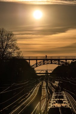 Kopenhag, Danimarka Carlsberg viyadük, 1899 'dan kalma çelik bir yaya köprüsü ve gün batımında tren rayları..