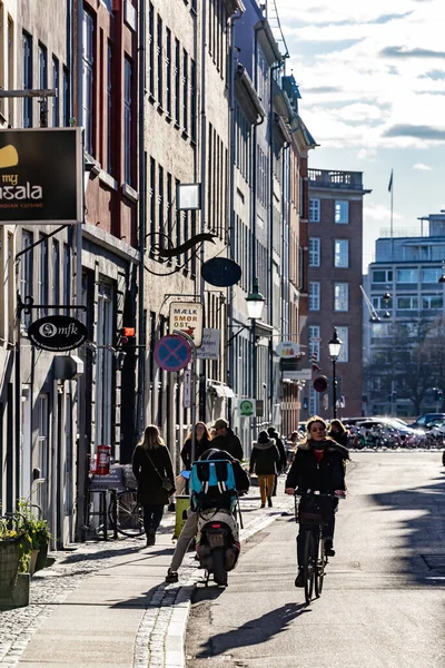 コペンハーゲン デンマーク春の日差しの中 ダウンタウンのランドマーク通りを自転車で走る女性 — ストック写真