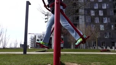 Kopenhag, İsveç. Bir kadın parkta spor salonunda bacak egzersizi yapıyor..  