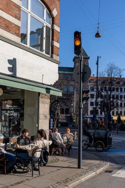 Kopenhag, Danimarka. İnsanlar Vesterbrogade 'de bahar güneşinin altında bir restoranda oturuyorlar..