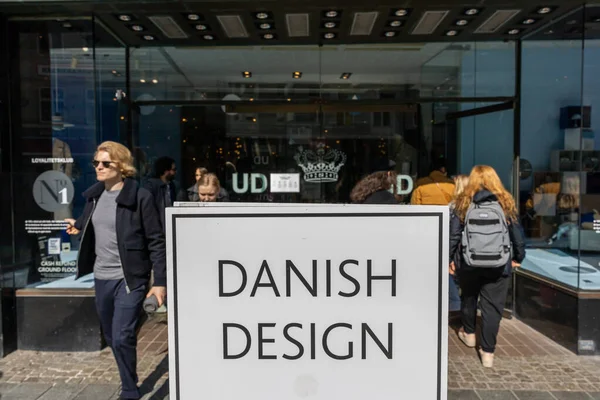 stock image Copenhagen, Denmark People walk by a store facade and a sign saying: 