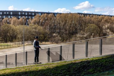Kopenhag, Danimarka 'da bir adam Copen Hill kayak sahasında kayak asansörüne biniyor. Kayak, bir elektrik santralinin ön cephesinde yer alıyor..