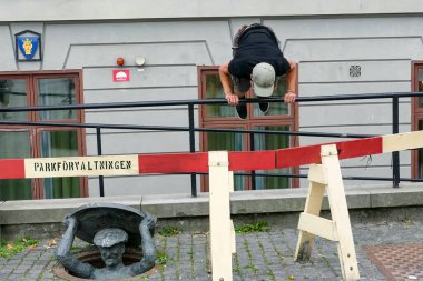 Stockholm, İsveç 'te bir adam Slussen bölgesinde bir heykel ya da bir insan heykeli olarak parcour adımları atar..