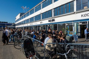 Kopenhag, Danimarka Eski Köfte Bölgesi 'nde bahar güneşinin altında açık hava restoranlarında ve barlarda oturan insanlar.