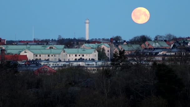 スウェーデンのストックホルム郊外の西のスカイラインの上に月が沈む — ストック動画