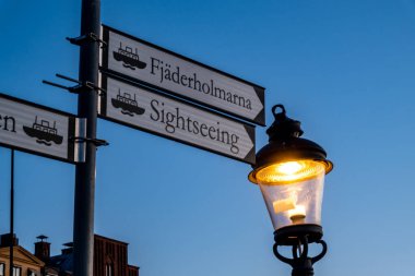 Stockholm, İsveç turist tabelaları şafak vakti ve Old Twon 'da bir sokak lambası veya Gamla Stan.