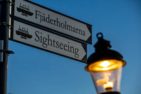 瑞典斯德哥尔摩的游客在黎明时分的方向标志和旧全 或Gamla Stan 的路灯 — 图库照片