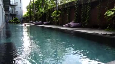 Canggu, Bali, Endonezya Bir adam sabah açık havuzda kurbağalama yüzer. 