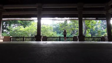 Ubud, Bali, Endonezya Büyük bir açık hava köşkünde bir kadın tek başına yürüyor. 