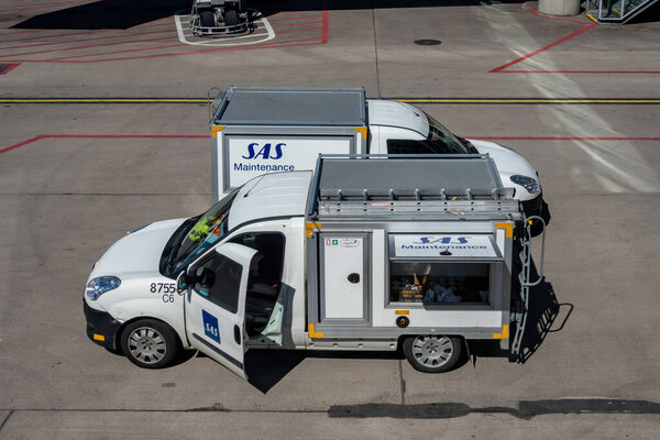 Стокгольм, Швеция Технический фургон SAS припаркован на взлетной полосе рядом с самолетом.