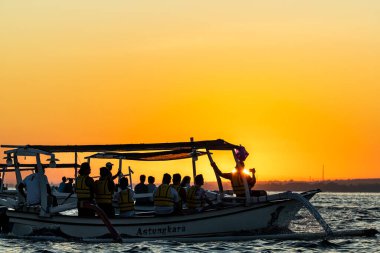 Geleneksel Endonezya balıkçı teknelerinde Lovina Sahili, Bali, Endonezya Turistleri şafak vakti yunusları tespit etmeye çalışırlar..