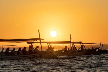 Geleneksel Endonezya balıkçı teknelerinde Lovina Sahili, Bali, Endonezya Turistleri şafak vakti yunusları tespit etmeye çalışırlar..