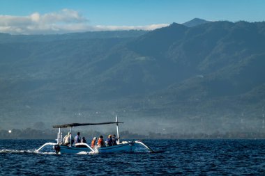 Geleneksel Endonezya balıkçı teknelerinde Lovina Sahili, Bali, Endonezya Turistleri şafak vakti yunusları tespit etmeye çalışırlar..