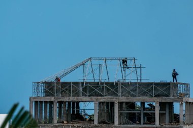 Canggu, Bali, Endonezya işçileri bir binanın tepesinde iskele yapıyor..