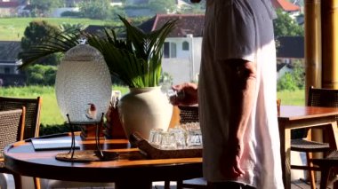 Bali, Endonezya Bir adam su testisinden bir bardak soğuk su alır