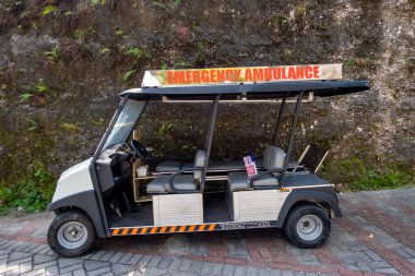 Bali, Endonezya, Denpasar dışındaki GWK Kültür Parkı 'nda acil durum ambulansı olarak etiketlenmiş Hindu tanrılarının heykelleri olan bir golf arabası..