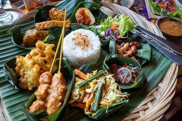 stock image An Indonesian dinner consisting of dmall dishes including satay, rice, tempeh and salads.