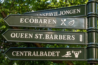 Stockholm, İsveç Parktaki İsveççe bir işaret Centralbadet, bir pastacı dükkanı ve ecobar da dahil olmak üzere farklı yerleri gösteriyor.,