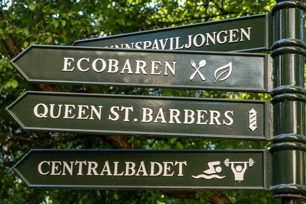 瑞典斯德哥尔摩一个在公园里用瑞典语写的标牌指向不同的地标 婴儿商店 生态塔 — 图库照片