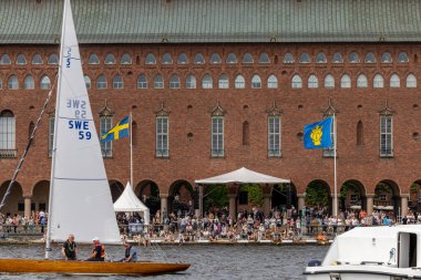 Stockholm, İsveç. Riddarfjarden 'de bir yelkenli yelkenli yarışı. Binanın 100. yıldönümünü kutlamak için belediye binasının önünde..