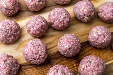 Çiğ, ev yapımı ve elle sarılmış İsveç köfteleri mutfak tezgahında kızartılmaya hazır..