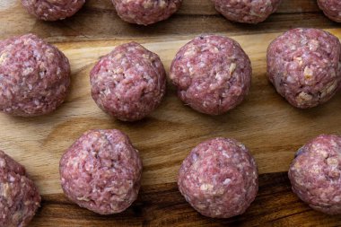 Çiğ, ev yapımı ve elle sarılmış İsveç köfteleri mutfak tezgahında kızartılmaya hazır..