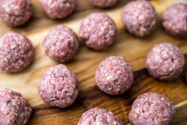 Çiğ, ev yapımı ve elle sarılmış İsveç köfteleri mutfak tezgahında kızartılmaya hazır..