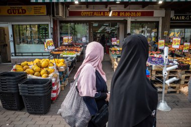 Stockholm, İsveç Kadın Alışverişçiler Etnik Skarholmen banliyösünün ana meydanında.