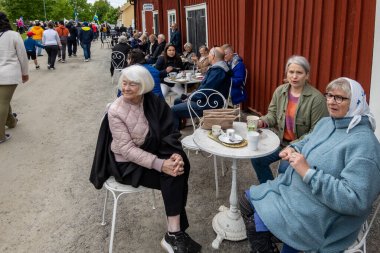 Skelleftea, İsveç 6 Haziran 2023 Kadınlar kahve içiyor ya da Bonnstan tarihi ve kültürel mahallesinde 6 Haziran, İsveç Günü.