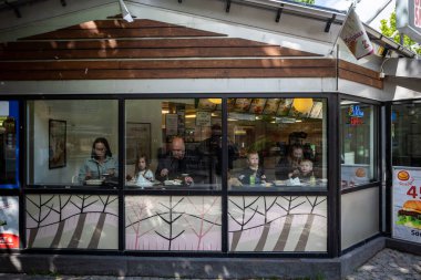 Skelleftea, İsveç 6 Haziran 2023 aile merkez meydandaki bir büfenin vitrininde yemek yiyor..