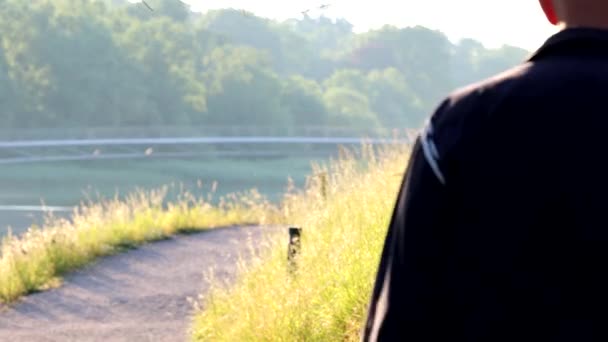 スウェーデン ストックホルムドゥルガーデン公園の道を早朝に歩く男 — ストック動画