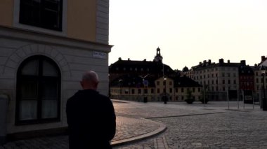 Stockholm, İsveç Birger Jarls Torg 'un Riddarholmen adasındaki manzarası ve yürüyen bir adam..