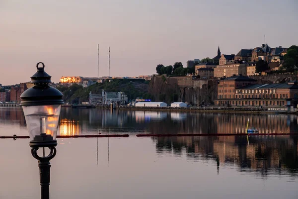 2023年7月1日 瑞典斯德哥尔摩旧城码头上的一个灯柱或夏季日出时的甘姆拉斯坦 朝索德马尔姆方向望去 — 图库照片