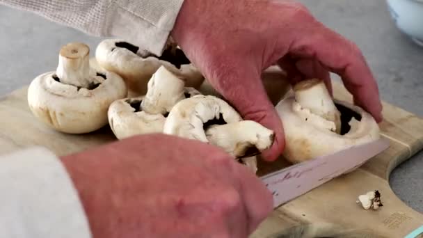 Ένας Αρσενικός Μάγειρας Κόβει Μανιτάρια Μια Ξύλινη Σανίδα Ένα Μαχαίρι — Αρχείο Βίντεο