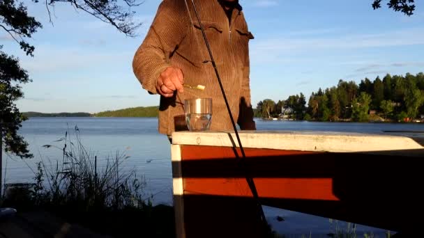 瑞典斯德哥尔摩一个男人在夜晚的阳光下在马拉伦湖边刷牙 — 图库视频影像