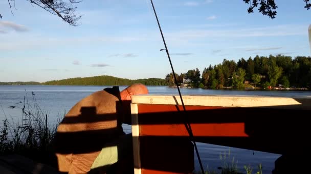 瑞典斯德哥尔摩一个男人在夜晚的阳光下在马拉伦湖边刷牙 — 图库视频影像