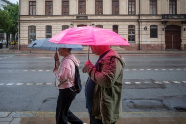 Stockholm, İsveç 6 Temmuz 2023 'te Sodermalm' da Gotgatan 'da yağmurda yürüyen yayalar.