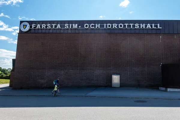 スウェーデンのストックホルム2023年7月9日ファースタ水泳やスポーツ施設のレンガ造りのファサードを過ぎて息子と歩くお父さん — ストック写真