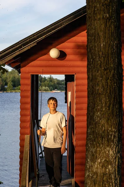 Estocolmo Suecia Adolescente Con Caña Pescar Frente Una Cabaña Roja — Foto de Stock