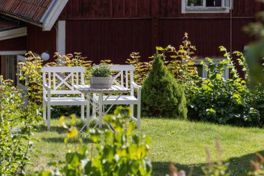 Taxinge, İsveç Kırmızı bir eve karşı yemyeşil bir yaz bahçesi..